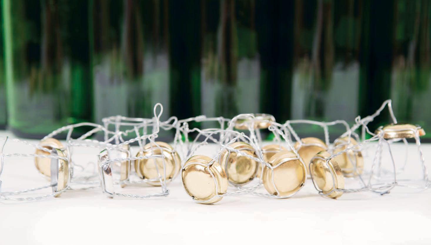 Miniature wire bicycles with golden wheels on a white surface.